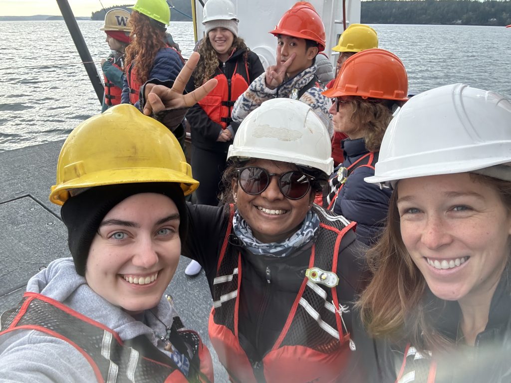 A group of people wearing hard hats are pictured on a boat.