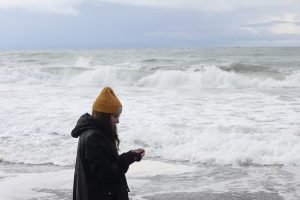 Mollie is pictured on a beach with waves.