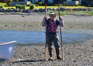 Erik Bengtson stands on a beach holding two paddles