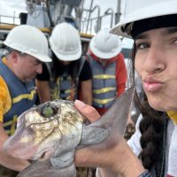 Ava Stoughton poses with a fish on a boat