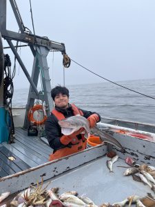 Diego Hernandez holds a small shark on a boat
