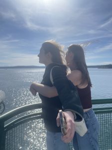 Two people stand hugging at the front of a ferry