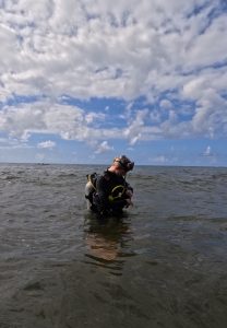 Olivia Hull stands in the water wearing scuba diving gear