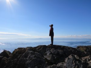 Kaelin Lindsey stands on a mountain top above the clouds