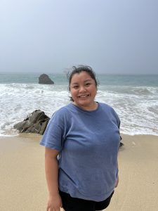 Alexias Thao stands on a beach