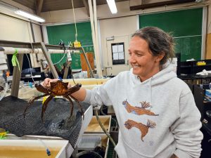 Wendy Porosky holding a large crab in a lab
