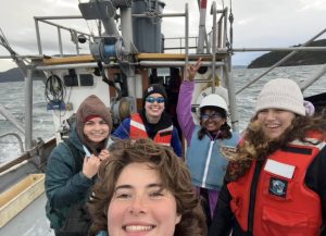 A group of students stand on a boat