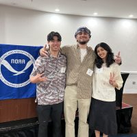 Three undergraduates stand in front of a NOAA podium.