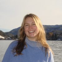 Student in front of water with sunlight coming from the right