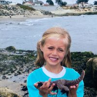 Childhood photo taken while tidepooling on the California coast holding a sea star. This image reflects my early fascination with marine life and coastal ecosystems.