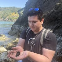 Man holding a prickeback in the intertidal at Deception Pass