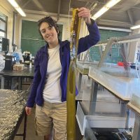 Student holding kelp in a lab
