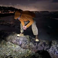 Man in orange jacket tide pooling