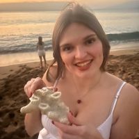 Woman holding coral on beach
