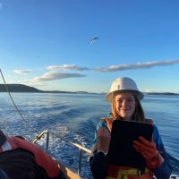 Student on research vessel in hard hat