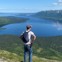 man from behind looking at body of water